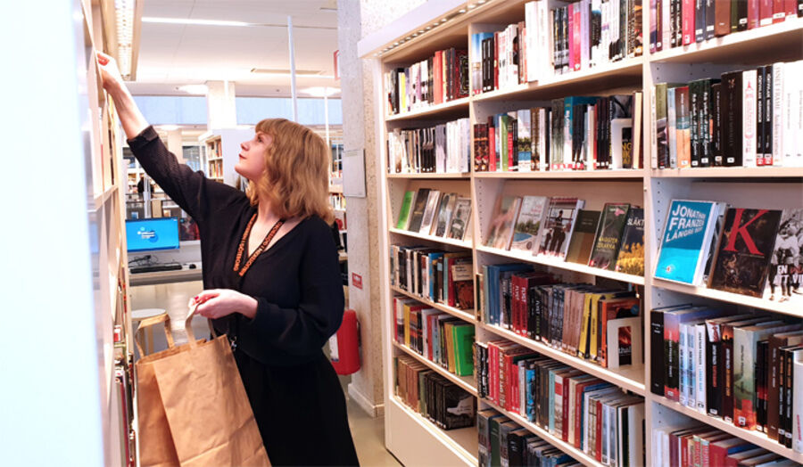 Bibliotekarie Maria Olsson packar en kasse till en låntagare.